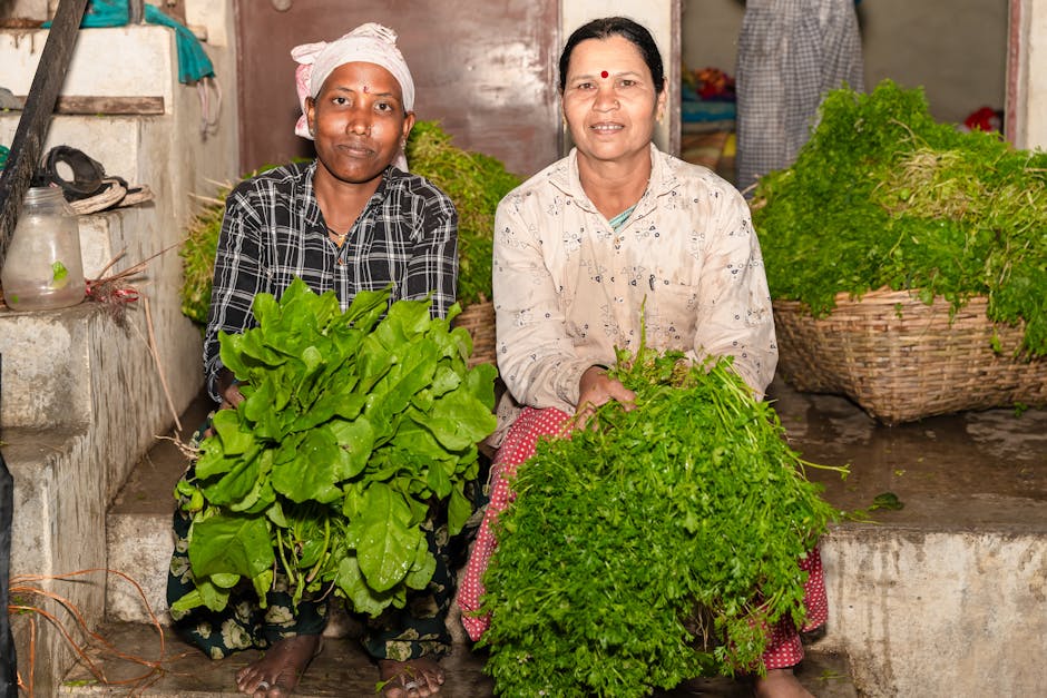 Two women farmers showcasing fresh greens in Nagpur, India, highlighting sustainable agriculture.