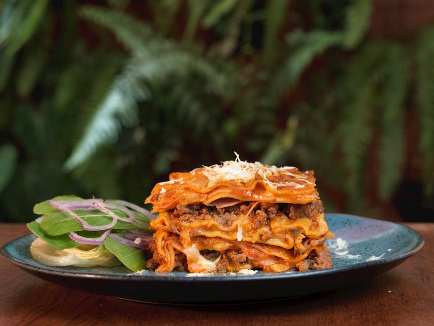 Appetizing lasagna served with a fresh salad, highlighted by vibrant colors and textures.